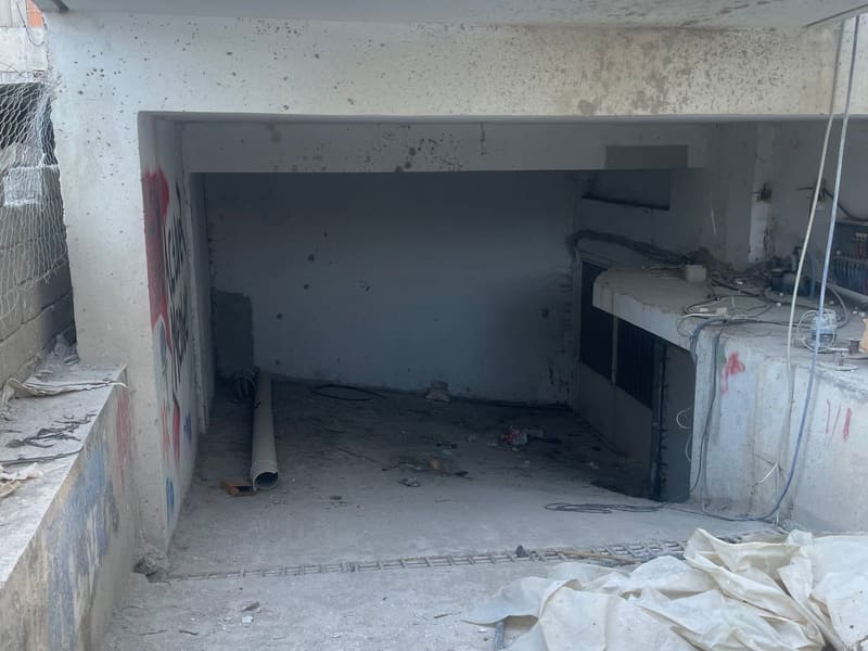 Χώρος σε ακατέργαστο σκυρόδεμα με εμφανή οπλισμό και σωληνώσεις — άλλο τμήμα του κτιρίου, σε φάση κατασκευής