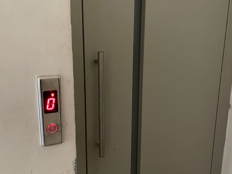 Πίνακας ένδειξης ορόφου και κουμπί κλήσης του ανελκυστήρα του κτιρίου